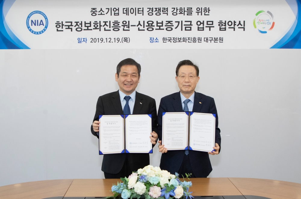 윤대희 신용보증기금 이사장(오른쪽)이 문용식 한국정보화진흥원장(왼쪽)과 함께 19일 대구 동구 한국정보화진흥원 본원에서 열린 ‘중소기업 데이터 경쟁력 강화를 위한 업무협약’에서 기념촬영을 하고 있다./사진=신용보증기금