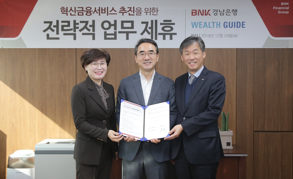 최우형 디지털금융본부 부행장보(오른쪽 첫번째)와 이정원 WM고객본부 상무가 BNK경남은행 본점을 방문한 배현기 웰스가이드 대표이사(가운데)와 ‘종합연금자문 혁신금융서비스 공동 개발을 위한 업무 협약’을 체결하고 있다./사진=경남은행