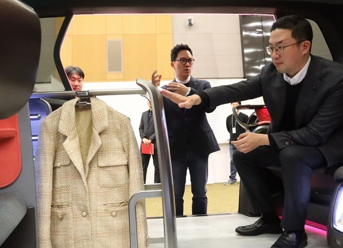 구광모 LG 회장이 LG전자 커넥티드 컨셉카에 설치된 의류기기를 살피고 있다. 사진=LG그룹.