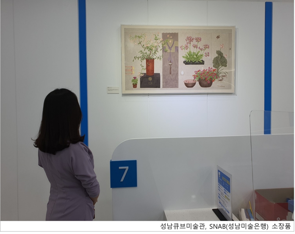 JT저축은행 본사에 전시된 '성남큐브미술관, SNAB(성남미술은행)' 소장품을 감상하고 있는 고객의 모습./사진=JT저축은행