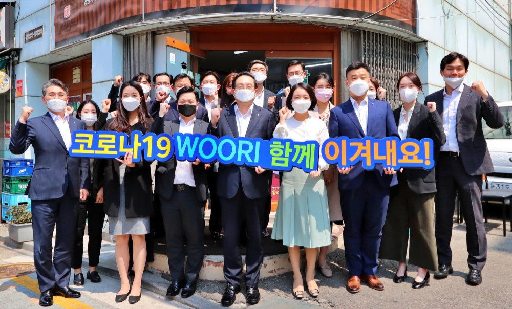 △ 손태승 우리금융그룹 회장(가운데)이 16일 본점 인근 식당에서 임직원들과 점심식사 후 코로나19로 어려움을 겪고있는 이들에게 응원의 메시지를 보내고 있다. /사진=우리금융그룹