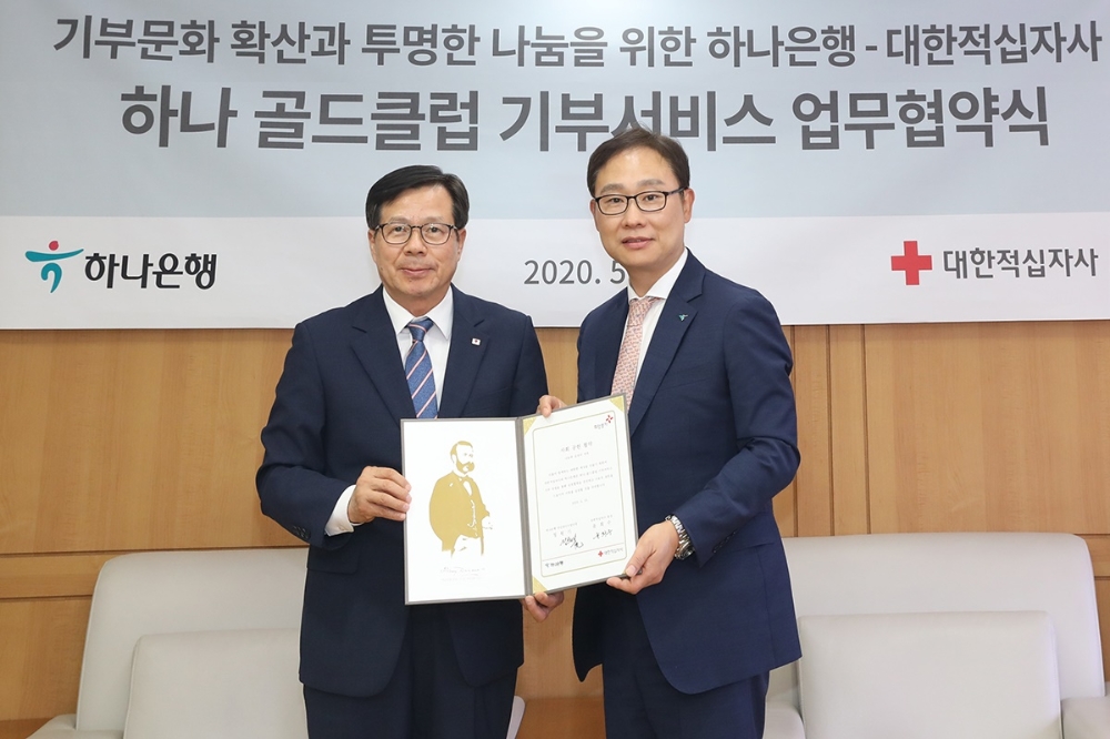 하나은행은 25일 대한적십자사 서울사무소에서 대한적십자사와 '하나골드클럽 기부 서비스'를 통한 기부금 조성 및 지급에 대한 업무협약을 체결했다. 협약식 후 정원기 하나은행 자산관리사업단장(사진 오른쪽)과 윤희수 대한적십자사 사무총장(사진 왼쪽)이 기념사진을 촬영하고 있다. / 사진= 하나은행(2020.05.26)