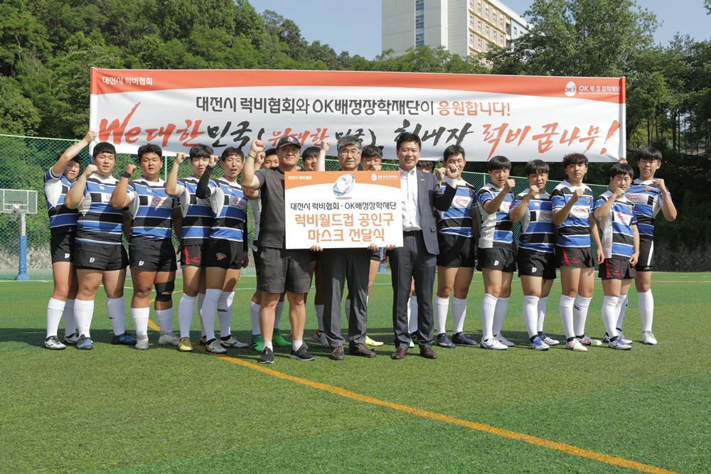 지난 3일 대전 명석고등학교 열린 ‘럭비 월드컵 공인구 및 마스크 전달식’ 후 임병권 명석고등학교 럭비부 감독(왼쪽 여섯번째부터), 남동균 대전시럭비협회장, 탁용원 OK금융그룹 스포츠단장 등 참석자들이 기념 촬영하고 있다./사진=OK배정장학재단