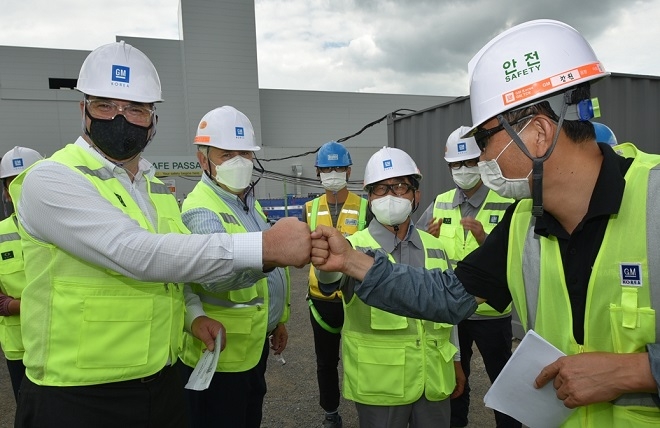카허 카젬 한국GM 사장(왼쪽)이 창원사업장 내 신형 CUV 생산을 위한 도장공장 공사 현장을 방문해 직원들을 격려하고 있다. 사진=한국GM.