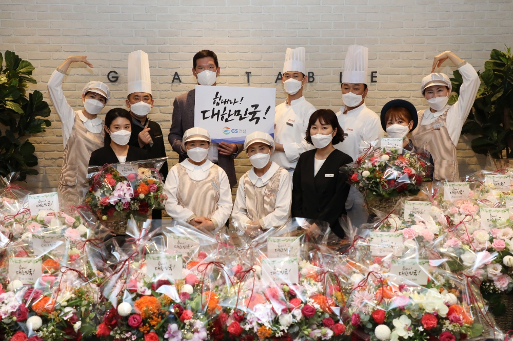 플라워 버킷 챌린지에 동참한 허윤홍 GS건설 신사업부문 대표(사진 윗줄 왼쪽에서 세 번째)가 GS건설 사원식당 외주업체 직원들과 기념사진을 촬영하고 있다. / 사진=GS건설