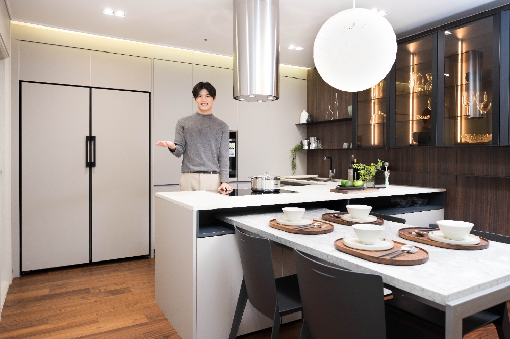 삼성전자 모델이 한샘 디자인파크 논현점에서 한샘 프리미엄 주방가구 '키친바흐'와 동일한 페닉스(FENIX) 소재의 도어 패널이 적용된 비스포크(BESPOKE) 냉장고 신제품을 소개하고 있다./사진=삼성전자