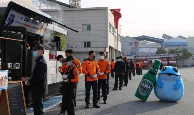 13일 충주소방서 소방대원들이 하이트진로가 지원한 '감사의 간식차' 앞에서 줄을 서고 있다. / 사진 = 하이트진로