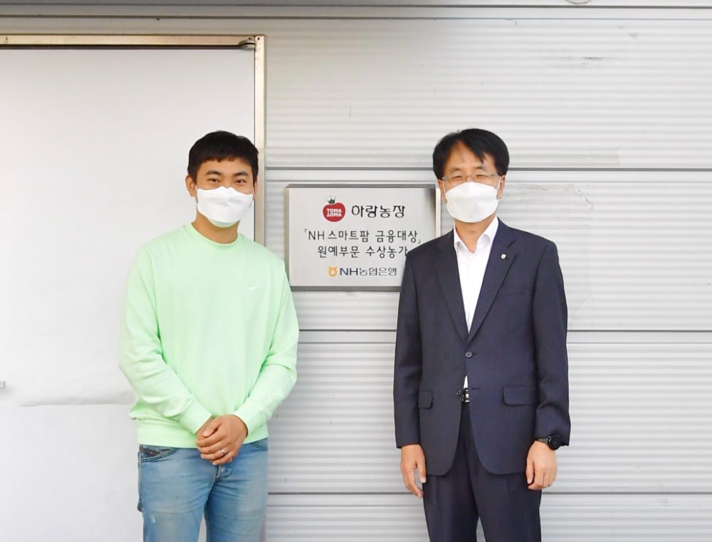 손병환 NH농협은행장(오른쪽)과 허정수 하랑농장 대표(왼쪽)가 지난 12일 전북 김제시에 위치한 ‘하랑농장’에서 ‘NH 스마트팜 금융대상’ 현판식을 진행했다. /사진=NH농협은행