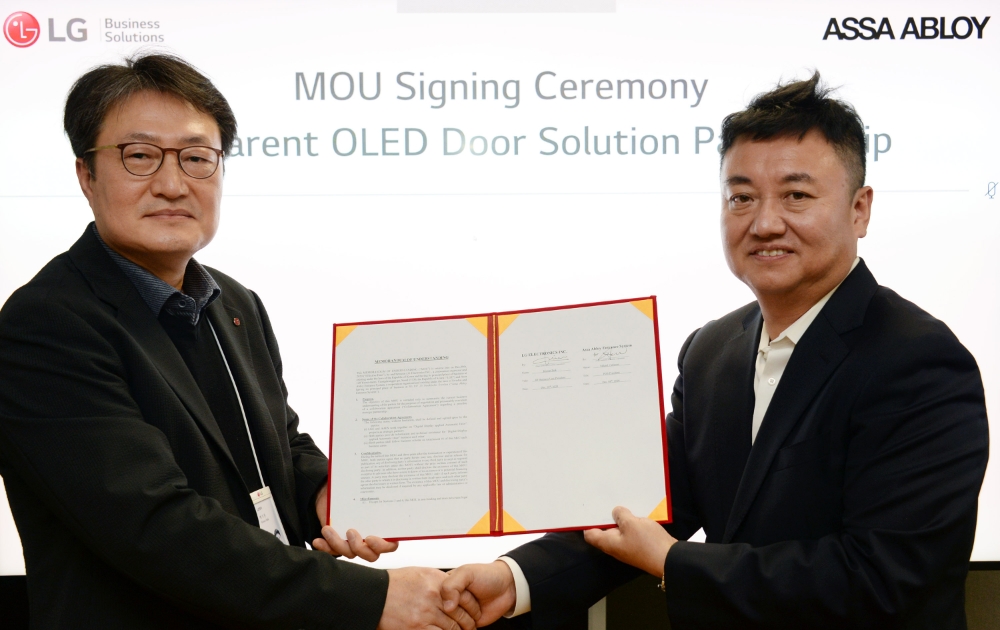 8일 오후 서울 여의도 LG트윈타워에서 열린 '투명 올레드 자동문 사업을 위한 업무협약' 체결식에 참석한 백기문 LG전자 ID사업부장 전무(왼쪽)와 길한솔 아사아블로이 엔트런스 시스템 대표이사 사장(오른쪽)이 기념촬영을 하고 있다. 사진=LG전자
