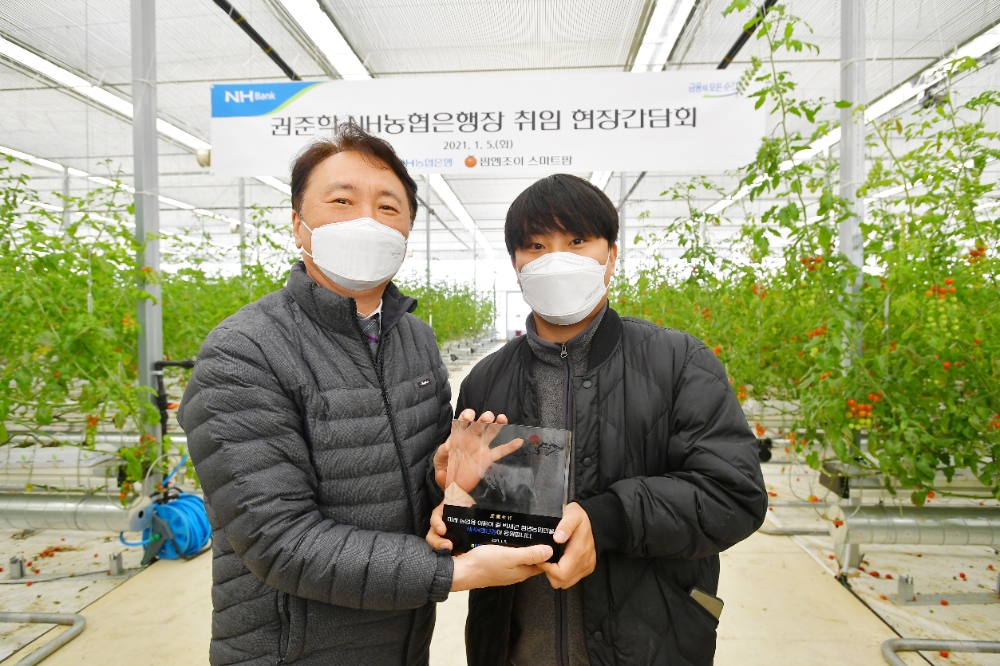 권준학 NH농협은행장(왼쪽)이 5일 충남 아산시 팜엔조이 농장을 방문해 현장 의견을 청취하고 박세근 대표와 기념촬영을 하고 있다./사진=NH농협은행