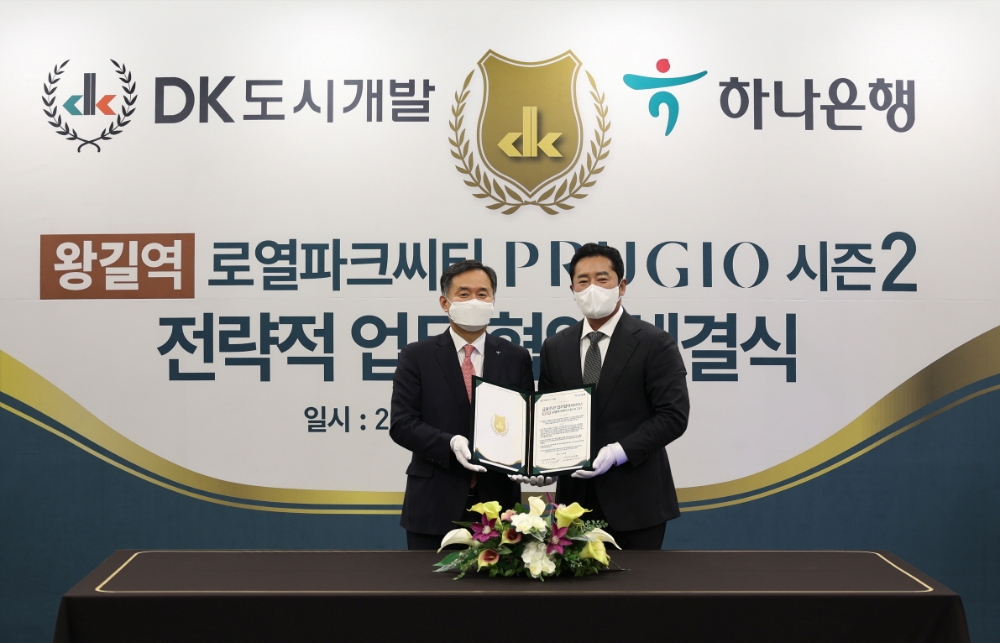 박지환 하나은행 CIB그룹 부행장과 김정모 DK도시개발·DK아시아 회장(오른쪽)이 지난 20일 ‘리조트 도시 시즌2, 왕길역 로열파크씨티’ 개발사업의 전략적 금융 주관 업무협약 체결 후 기념촬영을 하고 있다 . / 사진=더피알