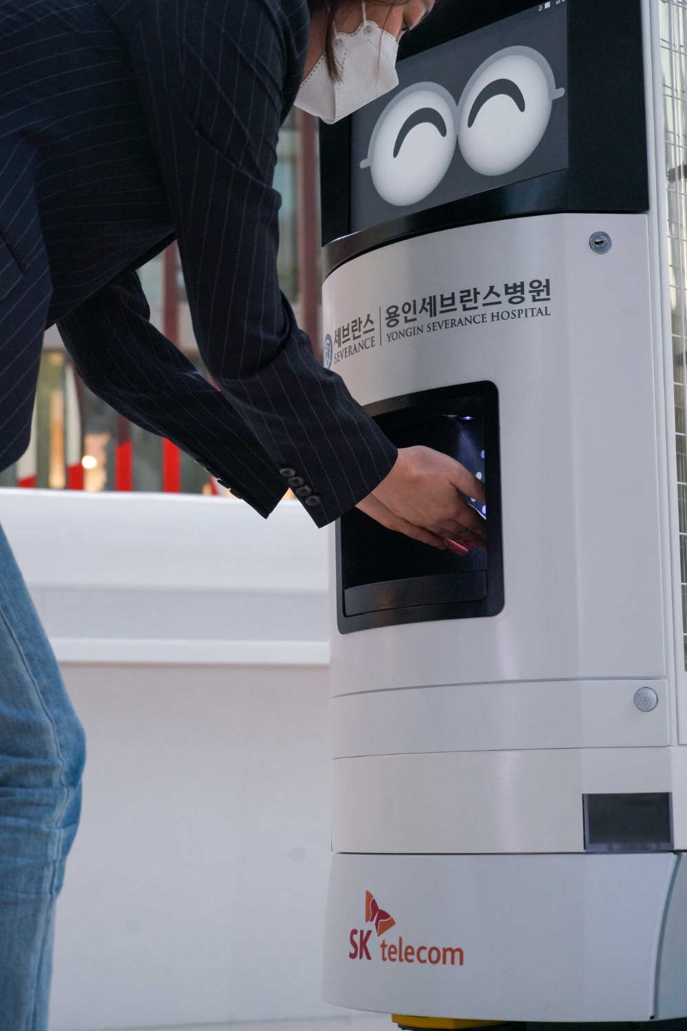 ‘Keemi’가 손소독제를 내원객에게 제공하는 모습. 사진=SK텔레콤