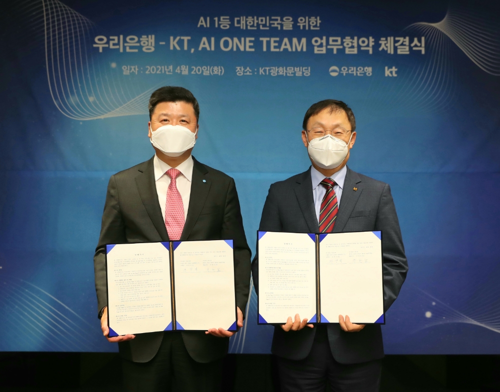 권광석 우리은행장(왼쪽)과 구현모 KT 대표이사가 20일 서울 KT 광화문 이스트 사옥에서 'AI원팀(AI One Team)' 업무협약을 체결한 뒤 기념촬영을 하고 있다./사진=우리은행