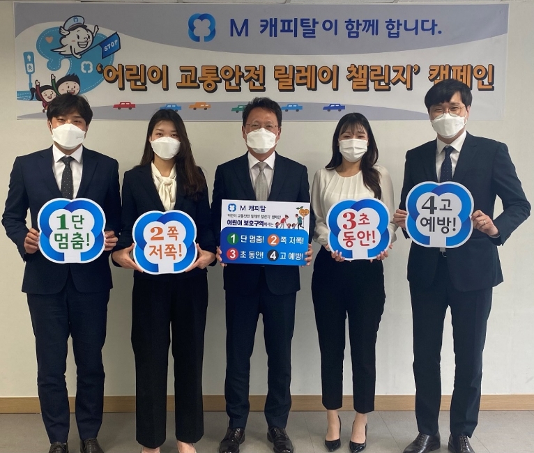 안정식 M 캐피탈 대표이사(가운데)가 직원들과 함께 어린이 교통안전 캠페인 슬로건 보드를 들고 있다. /사진=M캐피탈