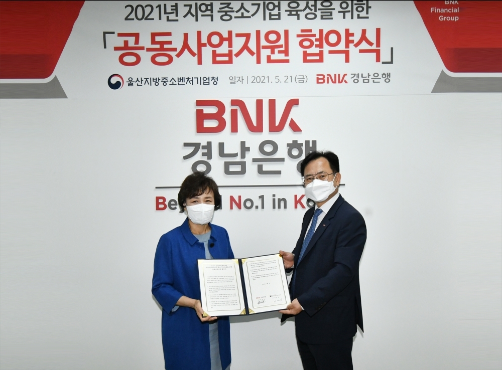 이상봉 BNK경남은행 상무(오른쪽)과 이영숙 울산지방 중소 벤처기업청장이 지난 21일 울산 신정동에 있는 BNK경남은행 울산영업본부에서 '지역 중소기업 육성을 위한 공동사업 지원 협약'을 체결한 뒤 기념촬영을 하고 있다./사진=BNK경남은행