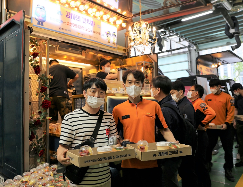 강남소방서 소방관들이 25일 ‘2021 감사의 간식차’ 간식을 수령하고 있다./ 사진제공 = 하이트진로