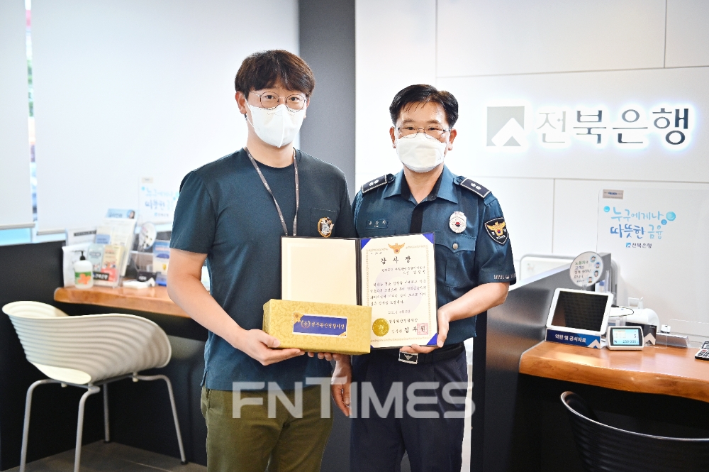 전주시 경원동에 있는 전북은행 '따뜻한 금융 클리닉 센터' 김진성 과장이 5일 보이스피싱 피해 예방에 결정적 역할을 한 공로를 인정받아 완산경찰서로부터 감사장을 받은 뒤 기념촬영하고 있다./사진=전북은행