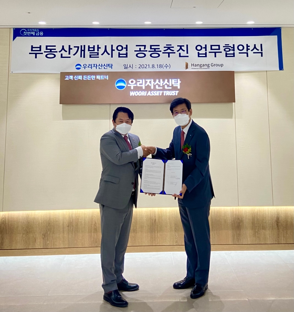 이창재 우리자산신탁 대표이사(오른쪽)와 고대웅 한강그룹 총괄대표가 협약식을 체결한 후 기념사진을 찍고 있다. / 사진=우리자산신탁