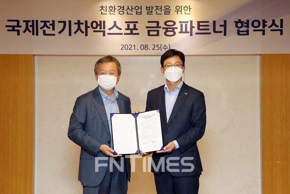 정지호 신한은행 부행장(오른쪽)과 김대환 국제전기자동차엑스포 이사장이 25일 서울시 중구에 있는 대한상공회의소에서 친환경 산업 발전을 위한 업무협약을 체결한 뒤 기념촬영하고 있다./사진=신한은행