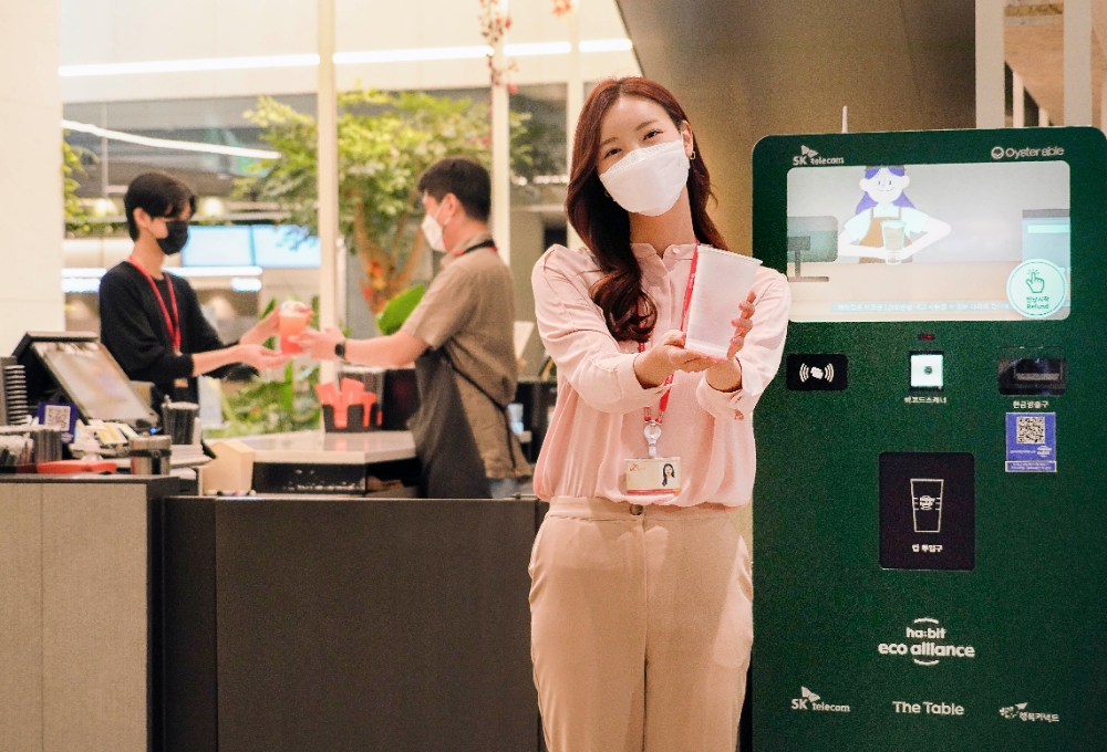 고객이 SKT 사내 카페에서 다회용컵에 음료를 받아 매장 안팎에서 자유롭게 이용한 뒤 무인 다회용컵 회수기를 통해 반납하고 있다. 사진=SK텔레콤