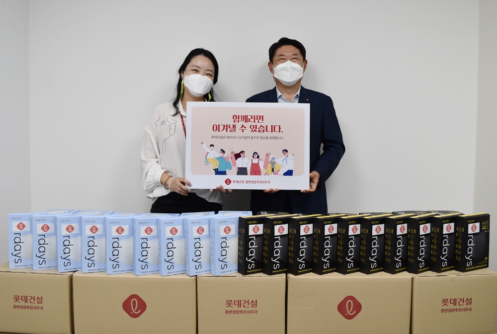 박은병 롯데건설 외주구매본부장(오른쪽)이 파트너사를 위해 준비한 마스크와 함께 기념 사진을 찍고 있다. / 사진제공=롯데건설