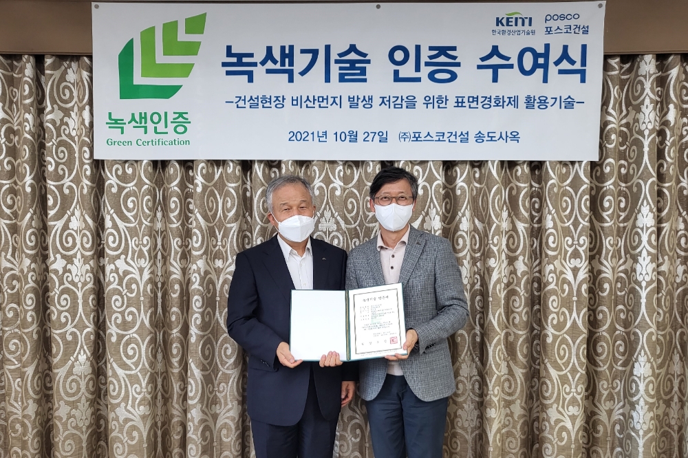 포스코건설이 개발한 건설현장 비산먼지 저감 기술이 지난 27일 포스코건설 송도사옥에서 환경부로부터 녹색기술 인증을 받았다. 김경호 한국환경산업기술원 환경기술사업본부장(왼쪽)과 김병곤 포스코건설 사업관리실장이 기념사진을 찍고 있다. / 사진제공=포스코건설