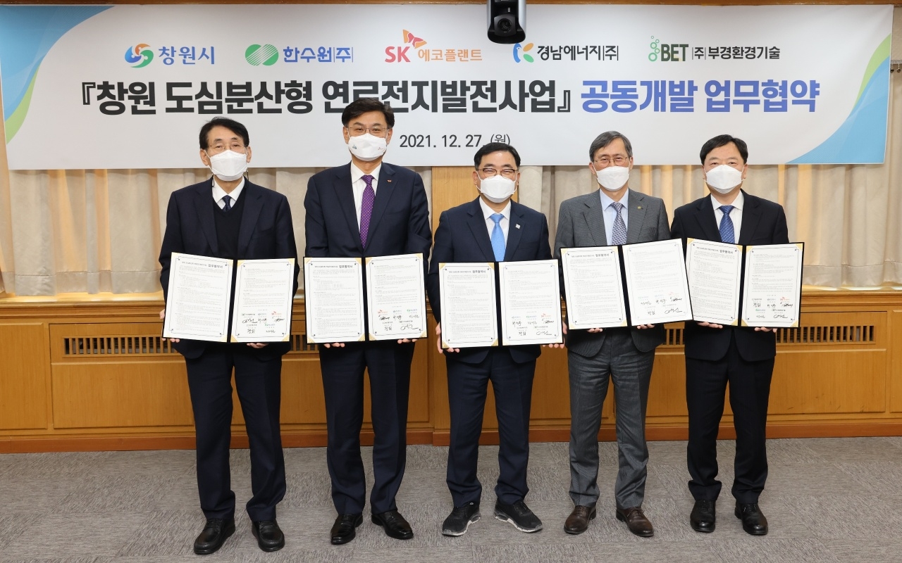 SK에코플랜트는 27일 창원시청에서 창원시, 한국수력원자력, 경남에너지, 부경환경기술과 ‘도심분산형 연료전지사업 공동개발협약(JDA)’을 체결했다. 사진은 협약식 행사에 참석한 이왕재 SK에코플랜트 에코에너지BU(Business Unit) 대표(왼쪽 두번째), 허성무 창원시장(왼쪽 세번째), 정재훈 한국수력원자력 사장(왼쪽 네번째), 정회 경남에너지 대표이사(왼쪽 다섯번째), 이병헌 부경환경기술 대표이사(왼쪽 첫번째) 등이 기념촬영을 하고 있는 모습. / 사진제공=SK에코플랜트, 한국수력원자력