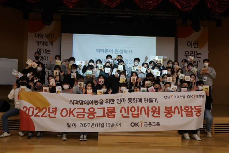 완성된 점자 동화책을 들고 포즈를 취한 신입사원 단체사진. /사진제공=OK금융그룹