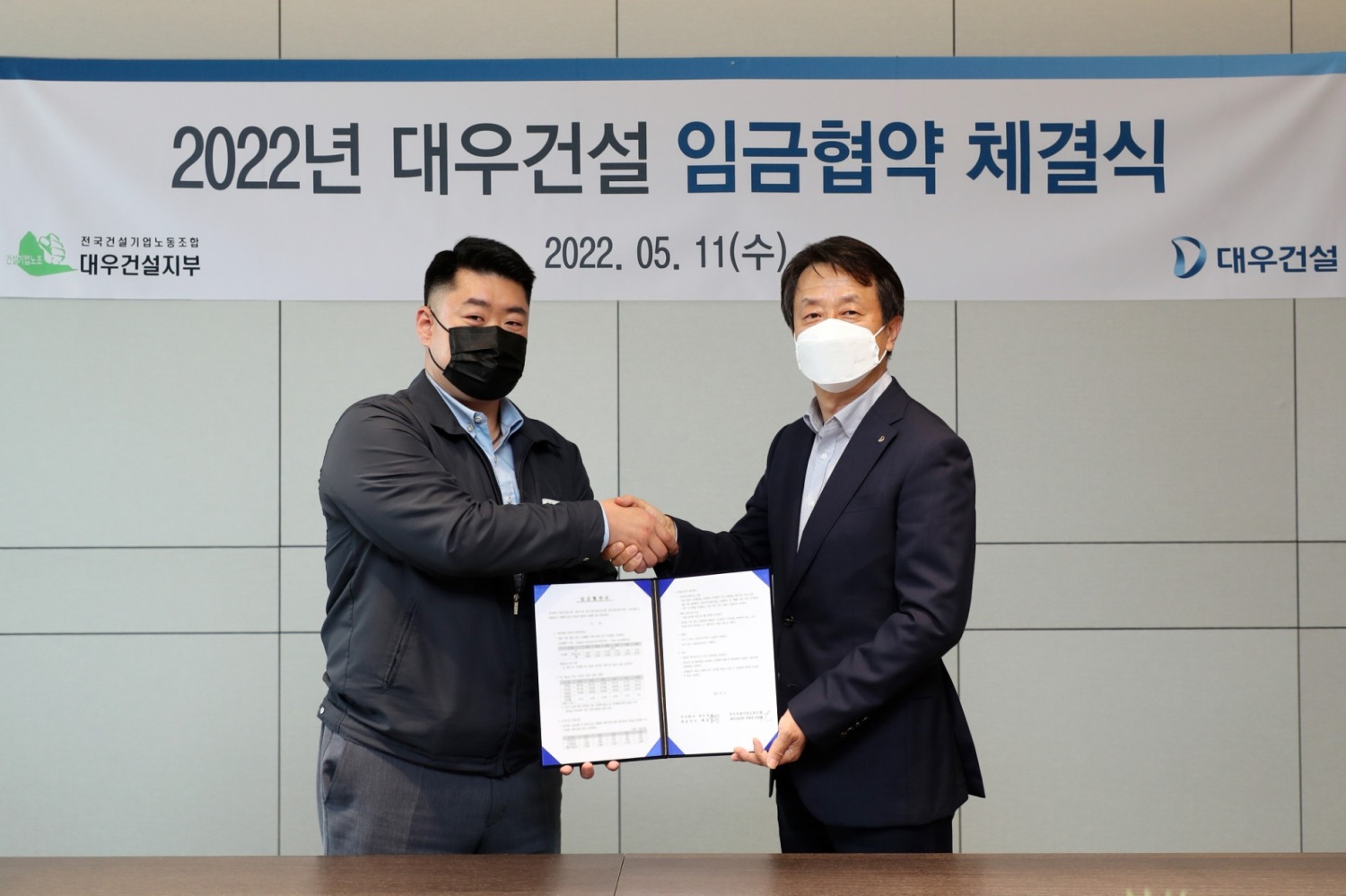 백정완 대우건설 대표이사(오른쪽)와 심상철 노동조합 위원장이 2022년 임금계약 체결식에서 악수를 나누고 있다. / 사진제공=대우건설