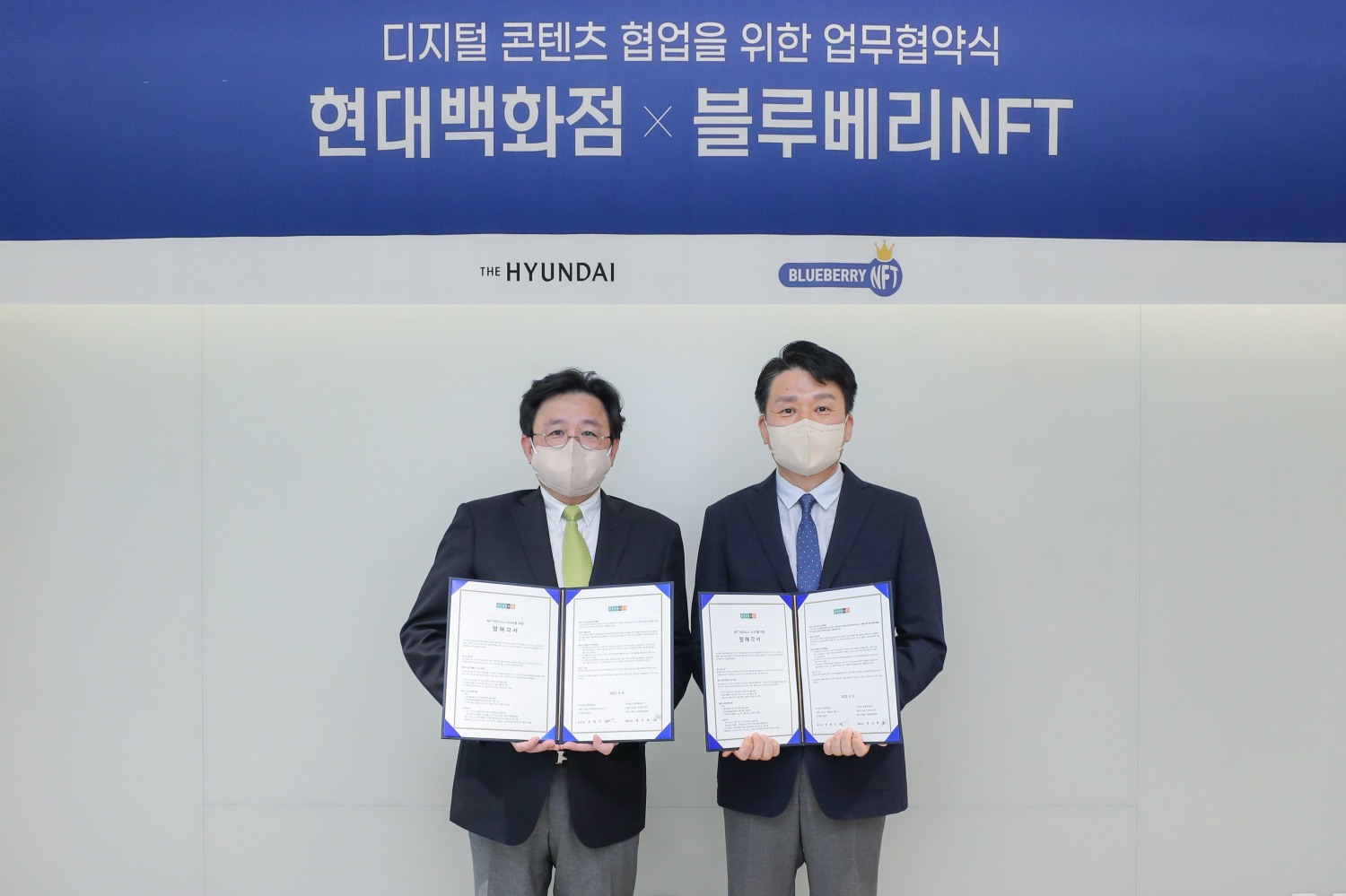 9일 서울 강남구에 위치한 현대백화점 사옥에서 권태진 현대백화점 디지털사업본부장(사진 오른쪽)과 홍상혁 블루베리NFT 대표이사(사진 왼쪽)이 MOU체결 후 기념촬영을 하고 있는 모습./ 사진제공 = 현대백화점그룹