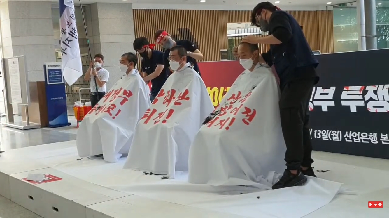 조윤승 산업은행 노조 위원장과 간부들이 13일 서울 여의도 산업은행 본점에서 '산업은행 부산 이전 반대'를 위한 삭발식을 진행하고 있다. 사진은 왼쪽부터 김광섭 금융노조 한국산업은행지부 부위원장, 조윤승 위원장, 김천순 수석부위원장. / 사진=금융노조 유튜브 갈무리