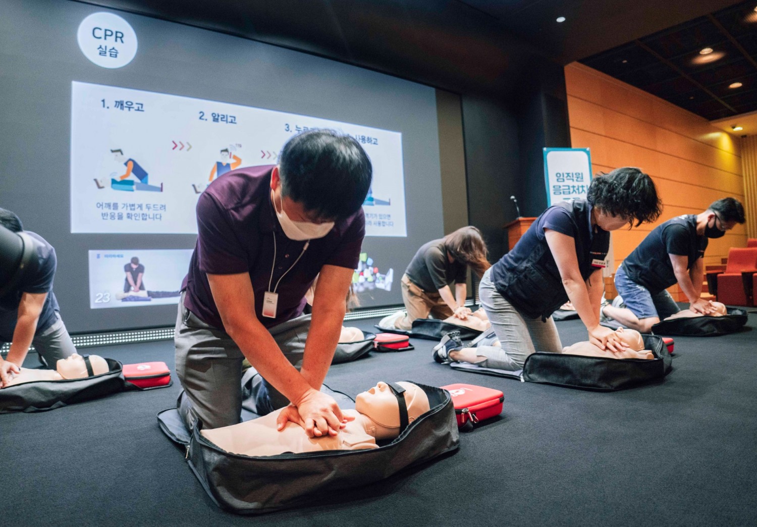 SK-T타워내 수펙스홀에서 강종렬 SKT CSPO(안전보건 최고경영책임자, 앞줄 왼쪽 첫번째)와 전환희 노조위원장(앞줄 왼쪽에서 두번째)을 비롯한 구성원들이 심폐소생술 실습 교육을 받고 있다. 사진=SK텔레콤