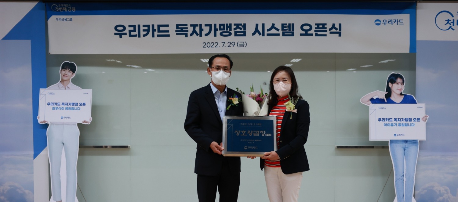 김정기 우리카드 사장(왼쪽)이 지난 29일 우리카드 광화문 본사에서 진행된 가맹점 식별 시스템 구축 기념 행사에서 가맹점 가입 1호 장호왕곱창 종로점주와 기념사진을 촬영하고 있다. /사진제공=우리카드