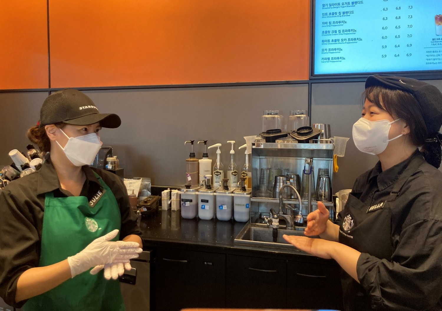 2022년 하반기 장애인 바리스타로 입사한 김정희 바리스타(왼쪽)가 동료 파트너와 수어로 대화를 나누고 있다./사진제공=스타벅스커피코리아