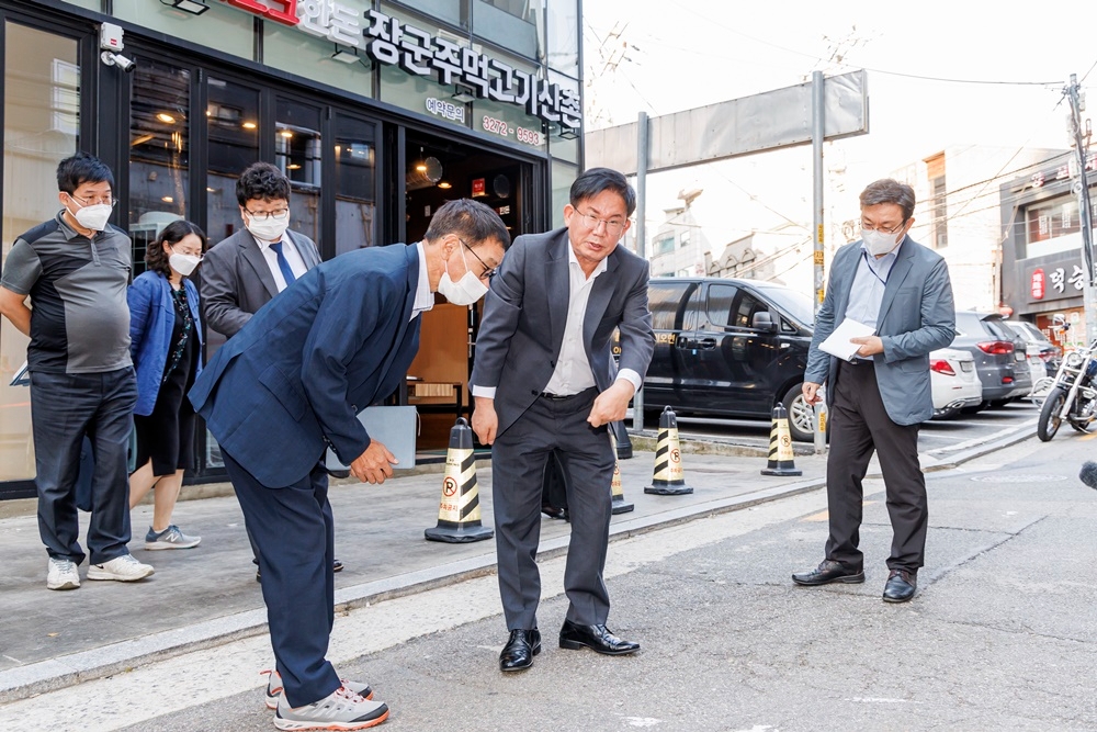 박강수 마포구청장(가운데)이 마포구 노고산동에서 도로 굴착복구 부실 상태를 점검하는 모습./사진제공=마포구