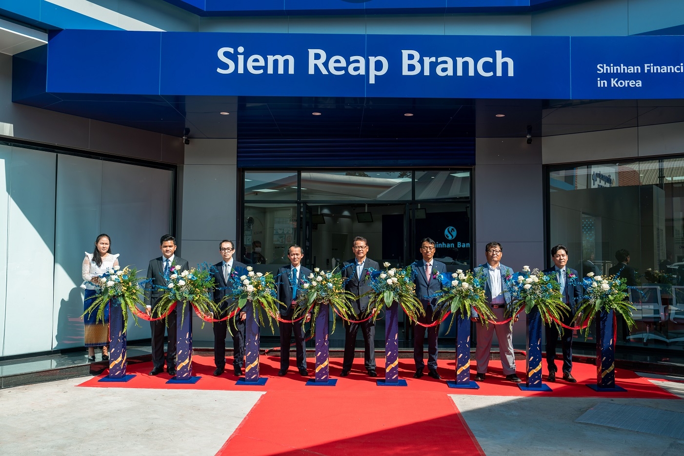 김남수 신한캄보디아은행 법인장(오른쪽에서 세번째), 박도권 주씨엠립 분관 총영사(오른쪽에서 네번째), 라이싸미은 중앙은행 씨엠립 지점장(왼쪽에서 네번째) 및 관계자들이 지난 17일 신한캄보디아은행 씨엠립 지점 개점식에서 커팅식을 하는 모습. / 사진제공=신한은행