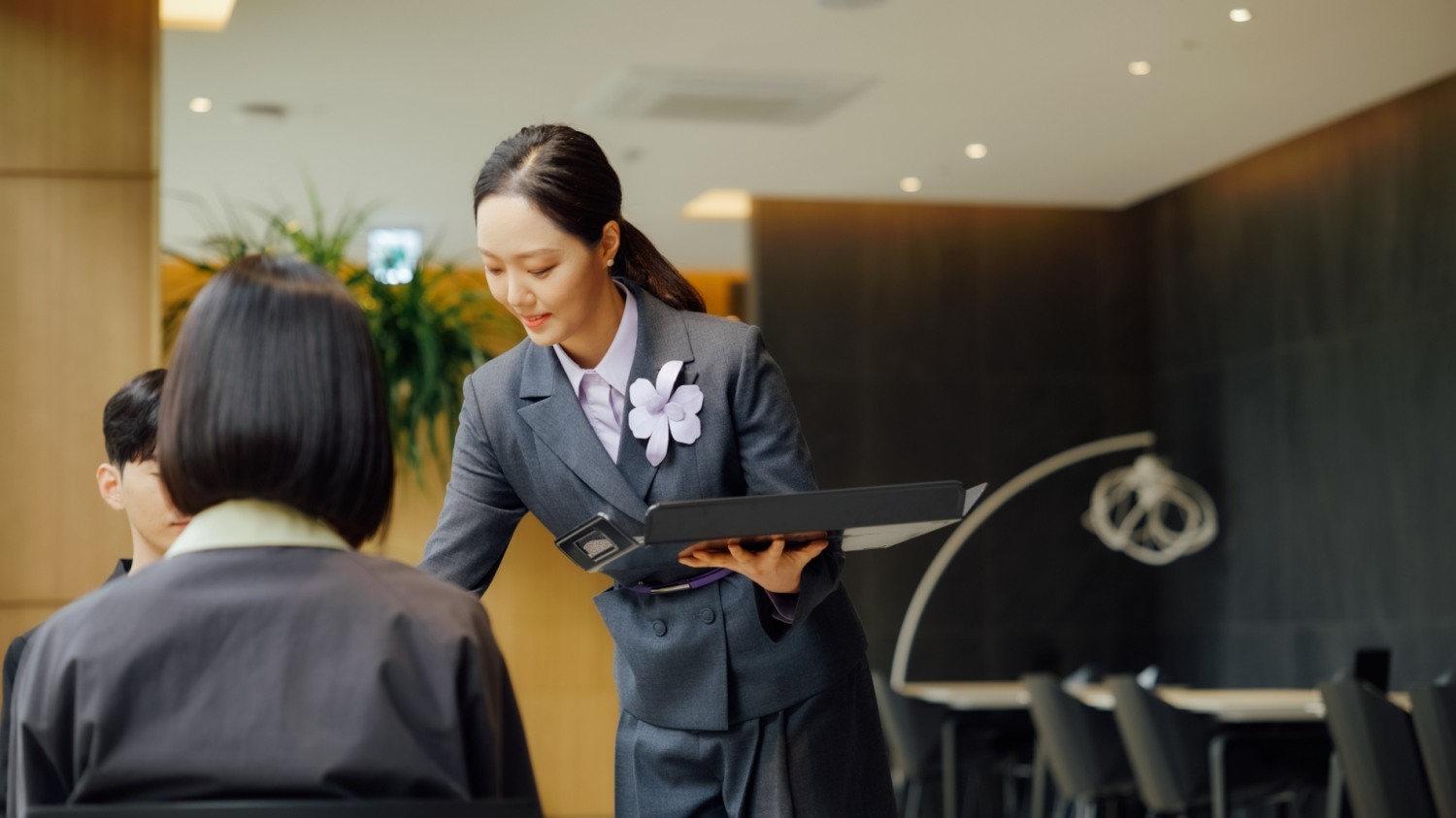 MVG라운지에서 직원이 새로운 유니폼을 입고 고객 응대를 하는 모습./ 사진제공 = 롯데쇼핑