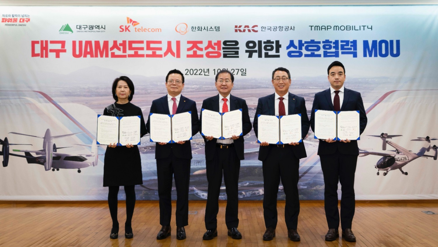 (왼쪽부터) 이미애 한국공항공사 부사장, 어성철 한화시스템 대표이사, 홍준표 대구시장, 유영상 SK텔레콤 사장, 박서하 티맵모빌리티 Future Mobility 담당이 27일 대구 엑스코(EXCO)에서 ‘도심항공교통(UAM) 시범사업 및 상용화 추진’ 업무협약(MOU)을 체결했다. 사진=티맵모빌리티