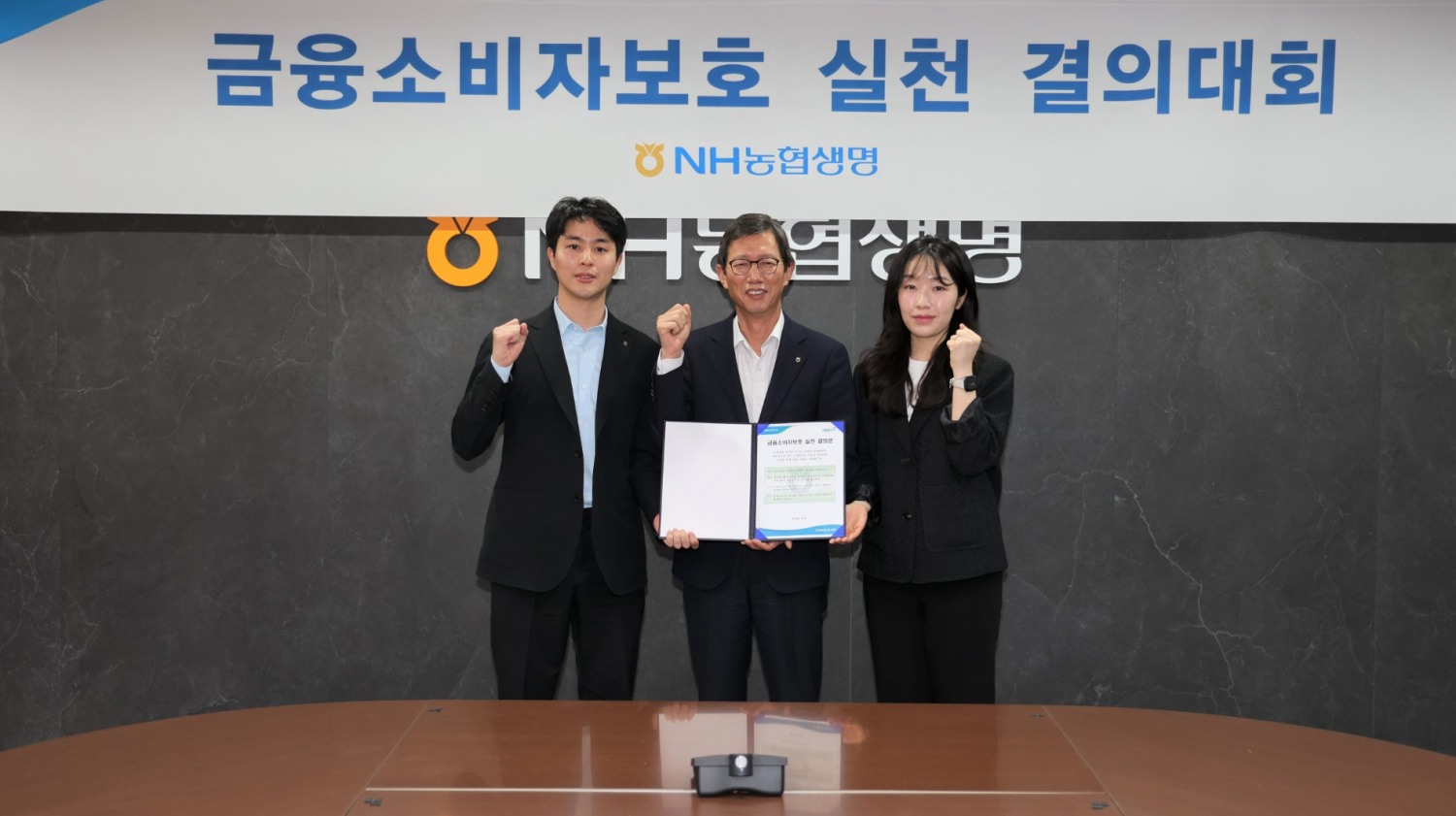 윤해진 농협생명 대표이사(가운데)와 임직원 대표 2명이 금융소비자보호 실천 결의대회를 기념해 사진 촬영을 하고 있다./사진=농협생명