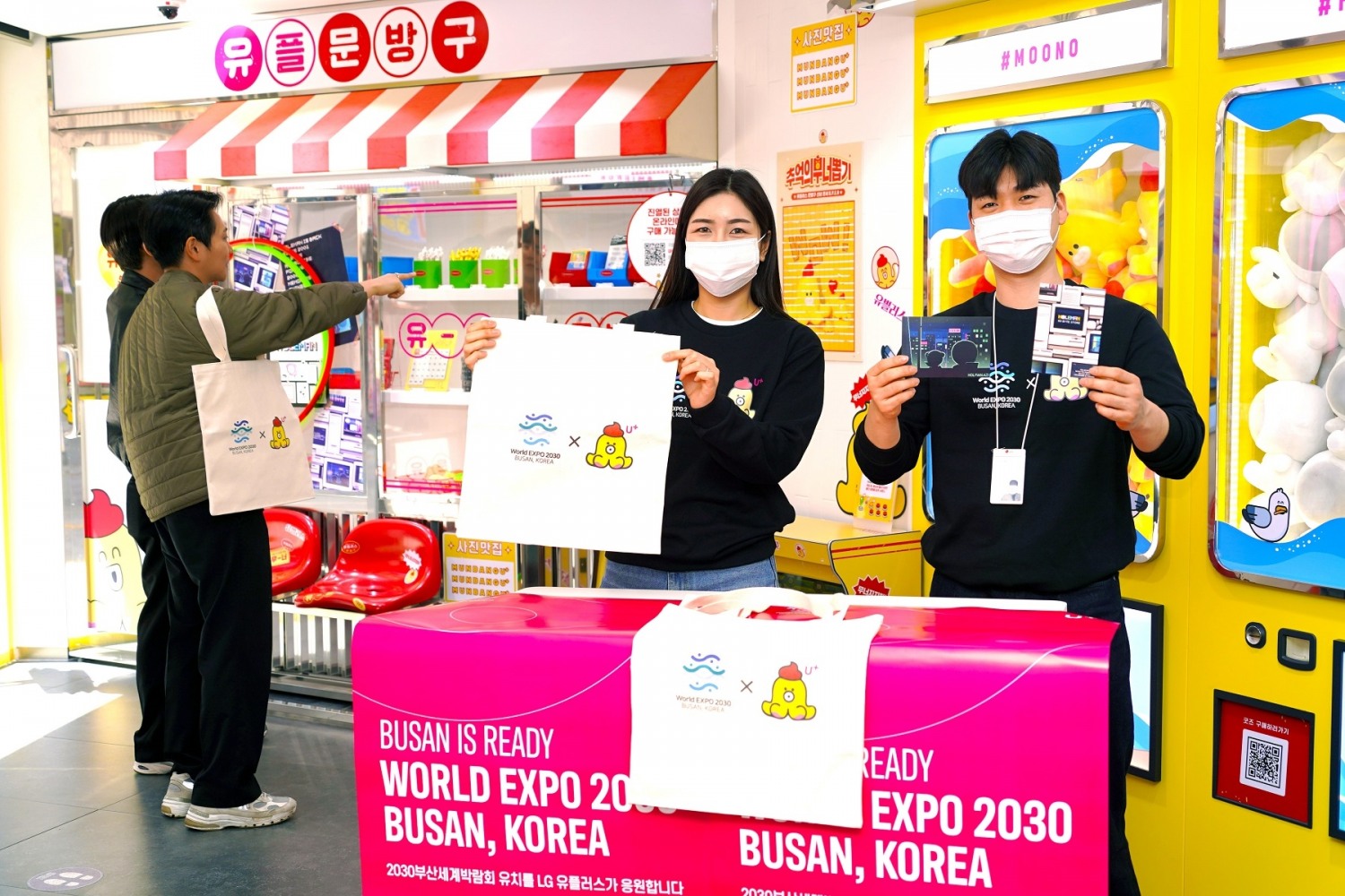 LG유플러스 임직원이 부산 서면에 위치한 언택트스토어에서 방문 고객에게 에코백을 선물하며 2030부산세계박람회 유치를 응원하고 있다. 사진=LG유플러스