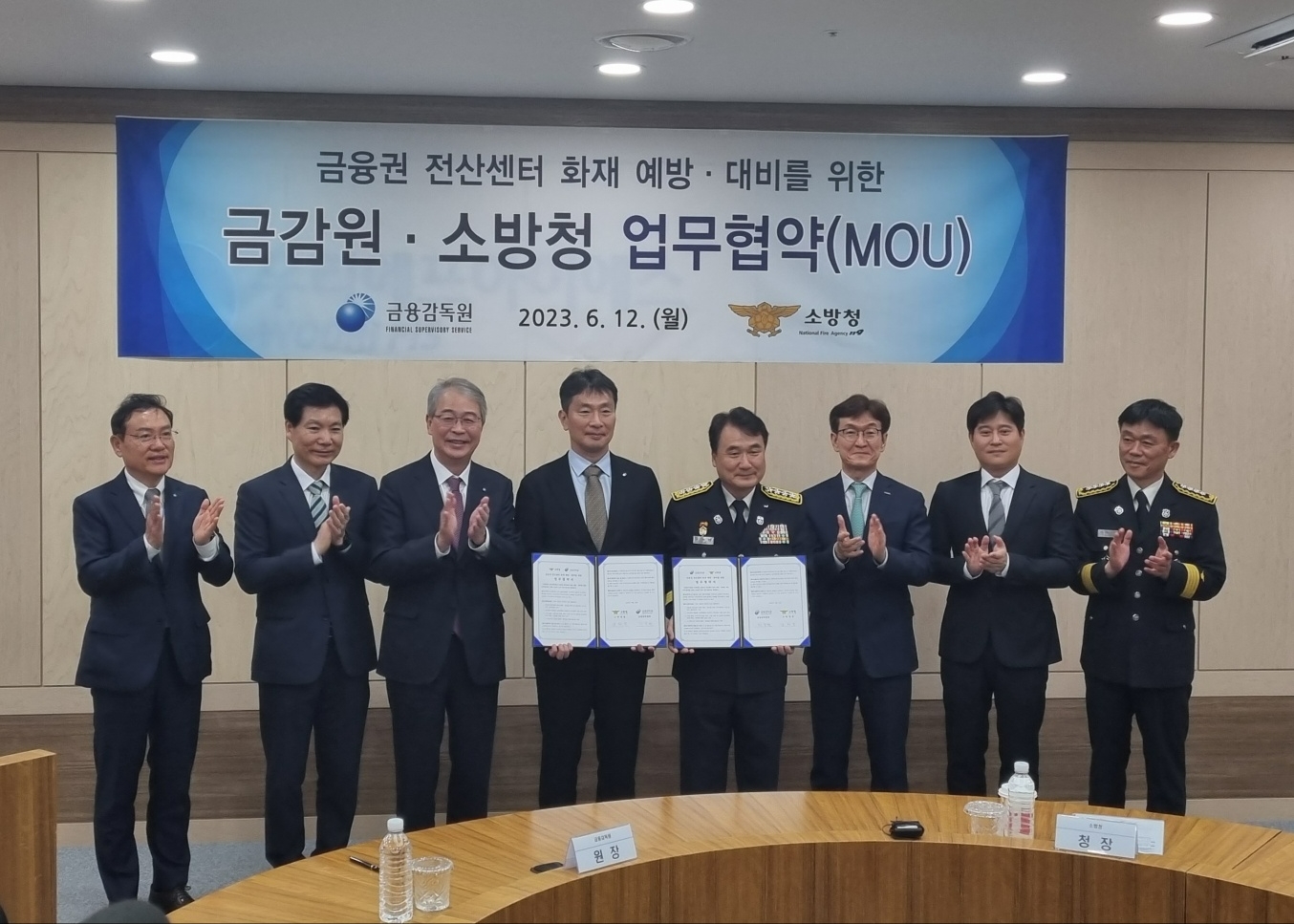 (왼쪽부터)고정현 우리에프아이에스 대표이사, 김병칠 금융감독원 부원장보, 임종룡 우리금융지주 회장, 이복현 금융감독원장, 남화영 소방청장, 홍우선 코스콤 대표이사, 신원근 카카오페이 대표이사가 기념촬영을 하고 있다.