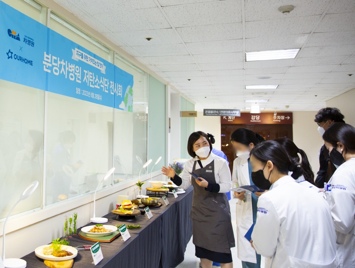 28일 경기 성남시 분당차병원 직원식당에서 열린 ‘저탄소 식단 전시회’에서 아워홈 영양사가 병원관계자들에게 비건 메뉴 6종을 소개하고 있다./ 사진 = 아워홈