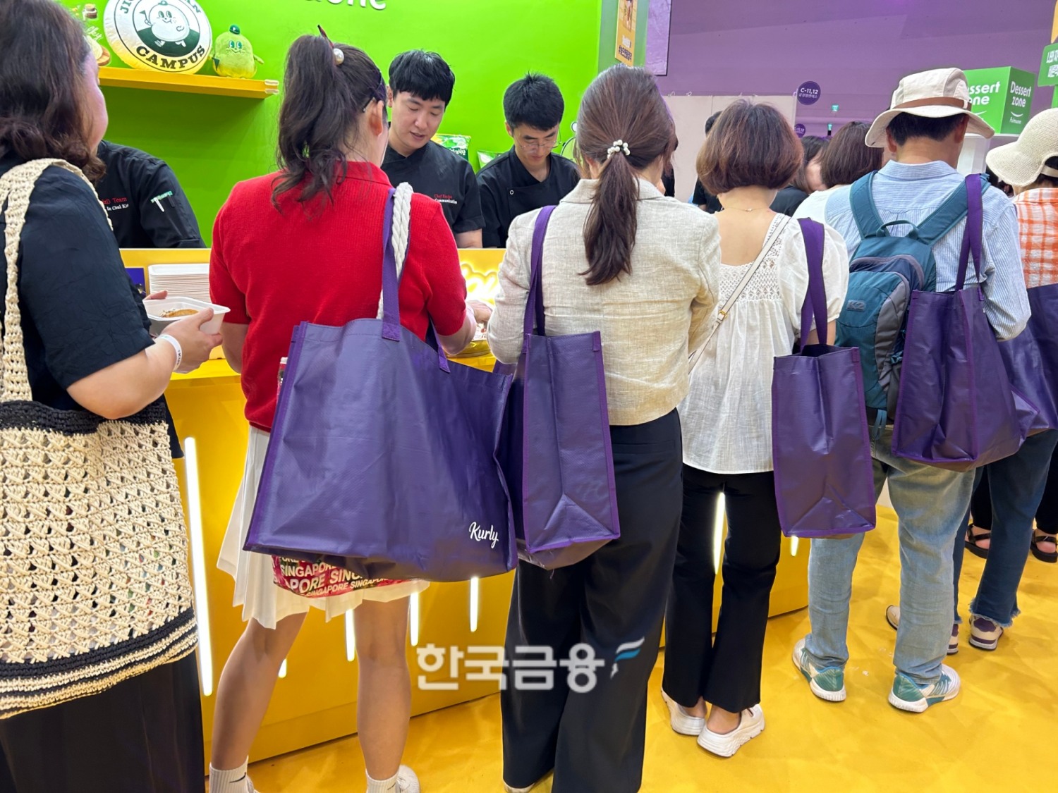 보라색 컬리 장바구니를 메고 줄을 길에 선 사람들의 모습. /사진=박슬기 기자