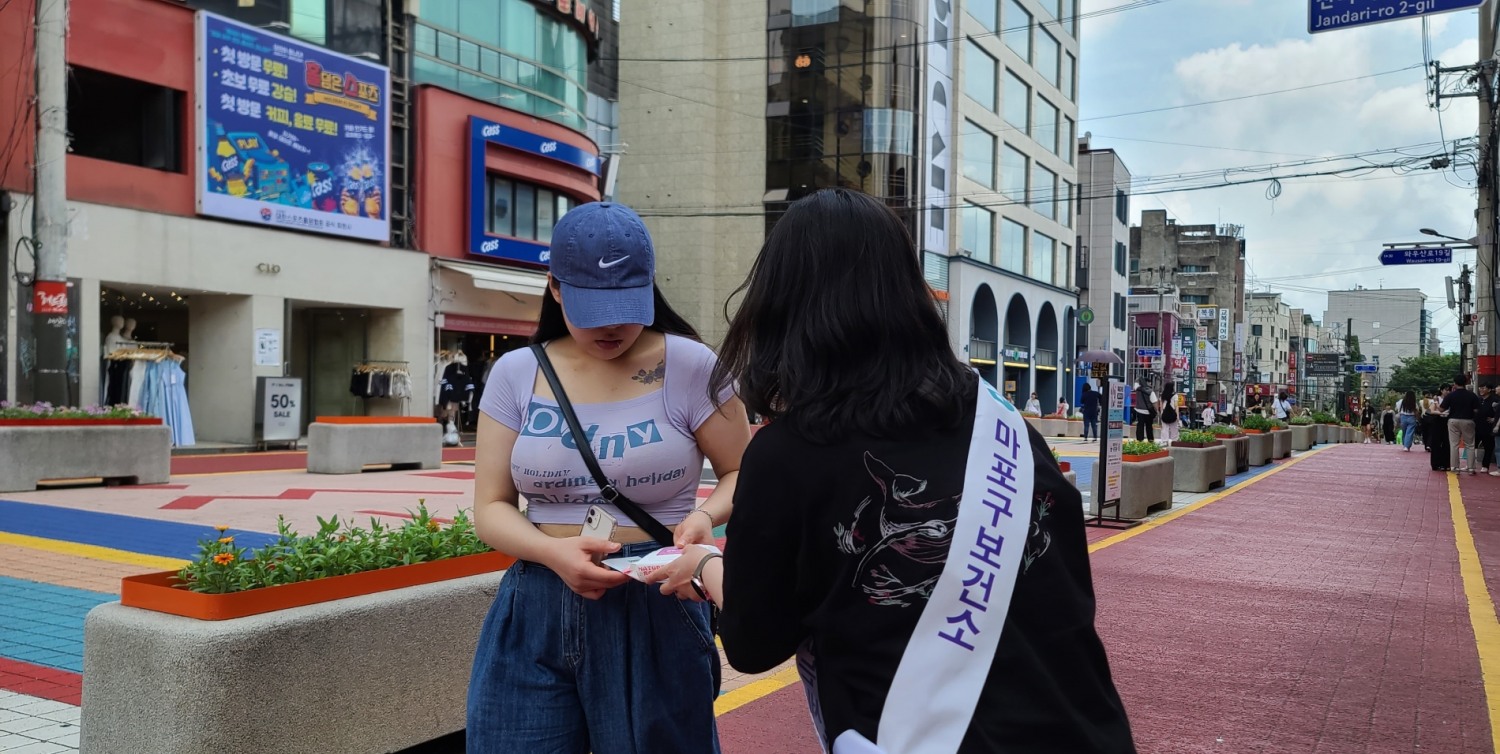 마포구보건소 직원이 홍대 레드로드에서 마약류 예방 캠페인을 펼치고 있다./사진제공=마포구