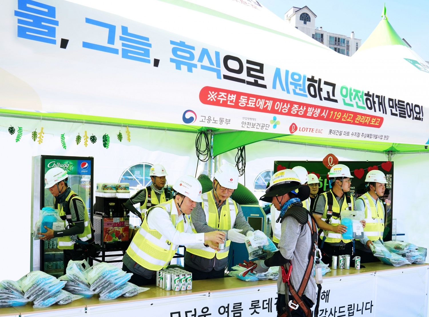 롯데건설 박현철 부회장(왼쪽 앞에서 두번째)이 혹서기 물품을 나눠주며 현장 근로자의 온열질환 예방 활동을 진행하고 있다. / 사진제공=롯데건설