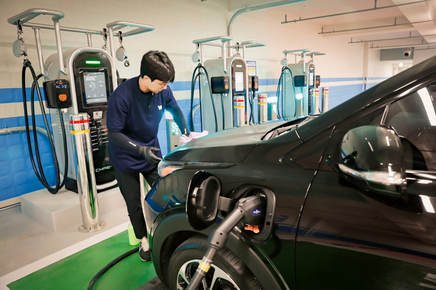 인스타워시 소속 세차전문가가 충전 중인 전기차를 워터리스 방식으로 세차하고 있다. 사진 제공=메리츠화재