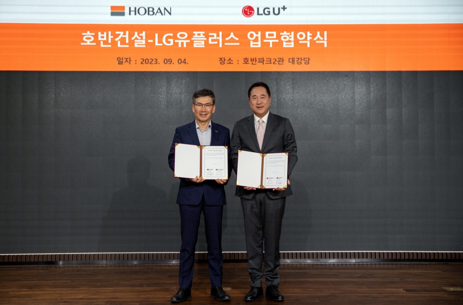 문갑 호반건설 경영부문장(왼쪽)과 현준용 LG유플러스 EV충전사업단장이 협약을 체결하고 기념촬영을 하는 모습./사진제공=호반건설