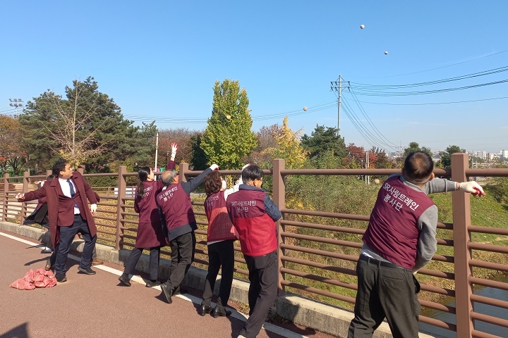 SR 직원들이 평택지제역 안성천에서 EM흙공을 던지는 모습./사진제공=SR