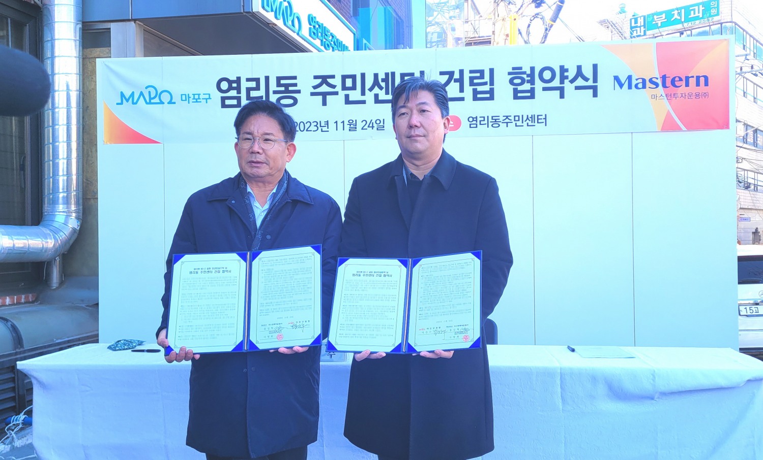 박강수 마포구청장(왼쪽)과 홍성혁 마스턴투자운용 대표이사가 염리동 주민센터 건립 협약을 체결하고 기념촬영을 하는 모습./사진=주현태 기자