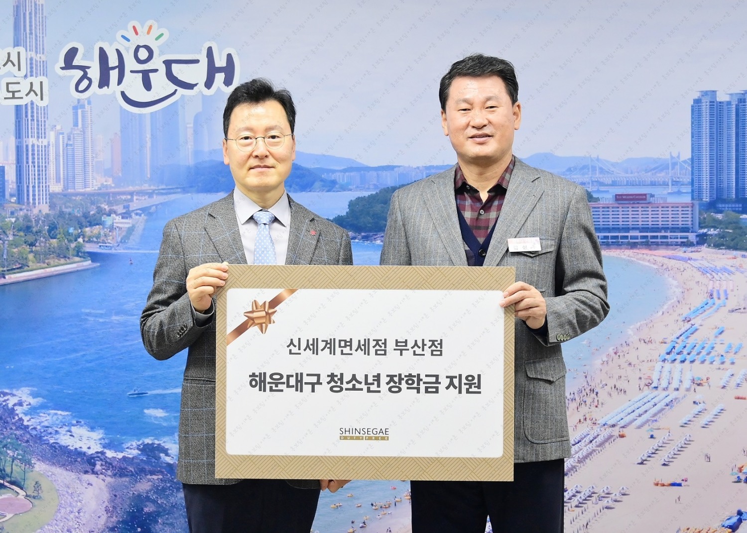 한세경 신세계면세점 부산점장(왼쪽)과 김성수 해운대구청장이 지난 12일 부산 해운대구청에서 열린 해운대구 청소년 장학금 증정식에서 기념촬영을 하고 있는 모습. /사진제공=신세계면세점